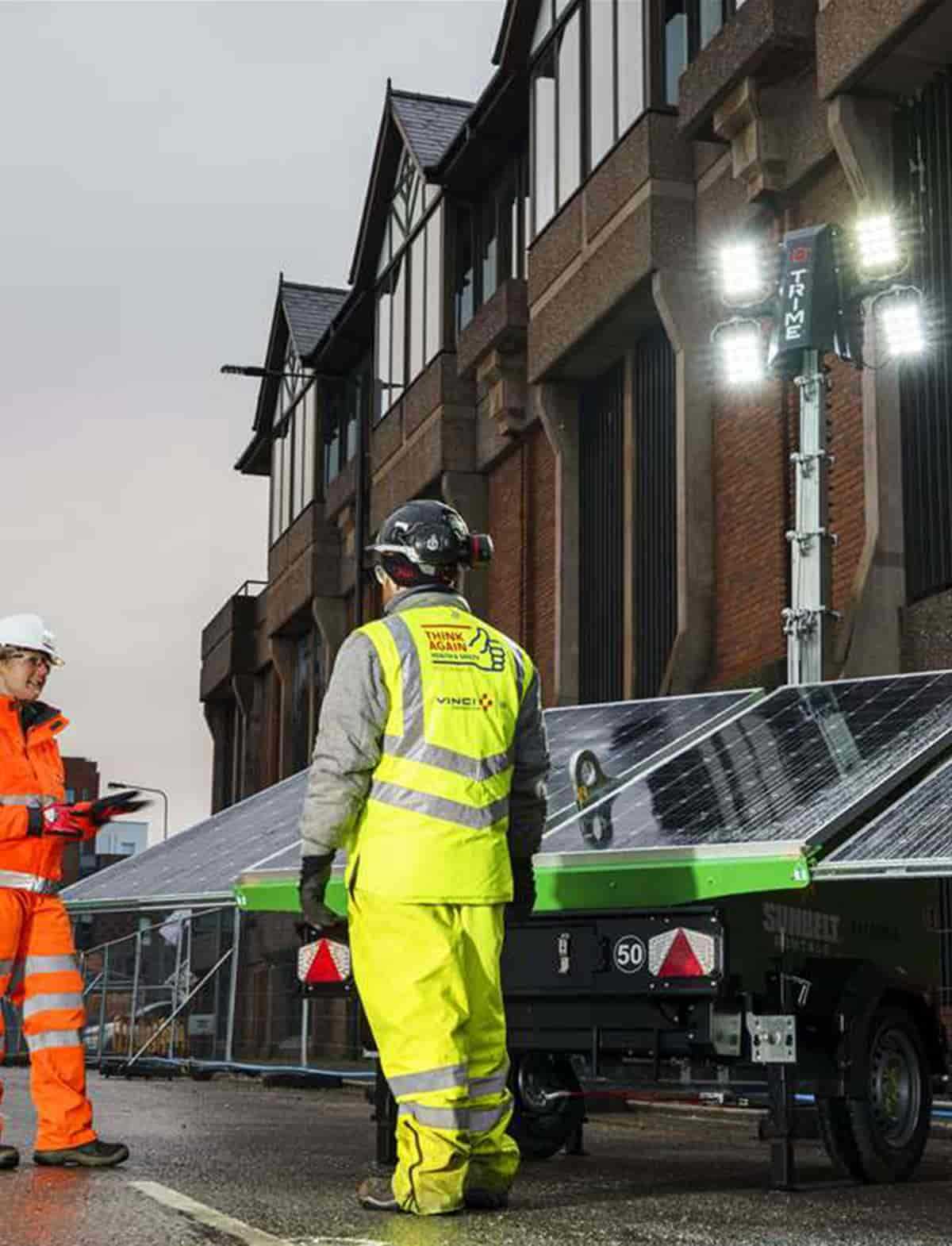 a Trime solar lighting tower with deployable solar panels working in road maintenance with two operators
