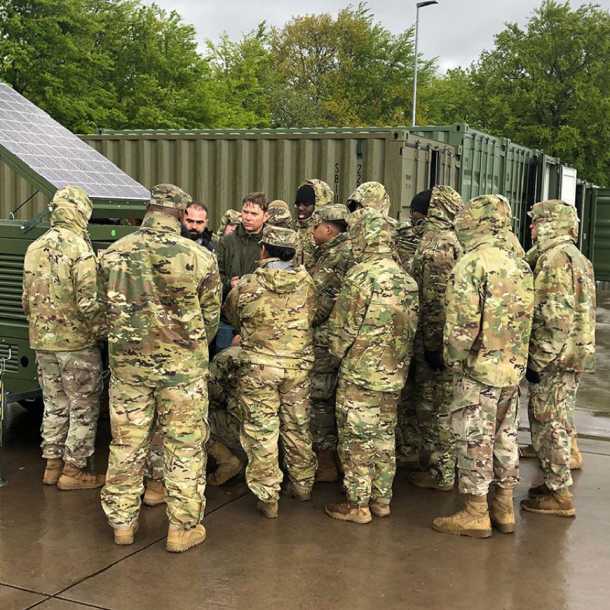 a group of soldier nearby a X-Solar Hybrid Lighting Tower with deployable solar panel